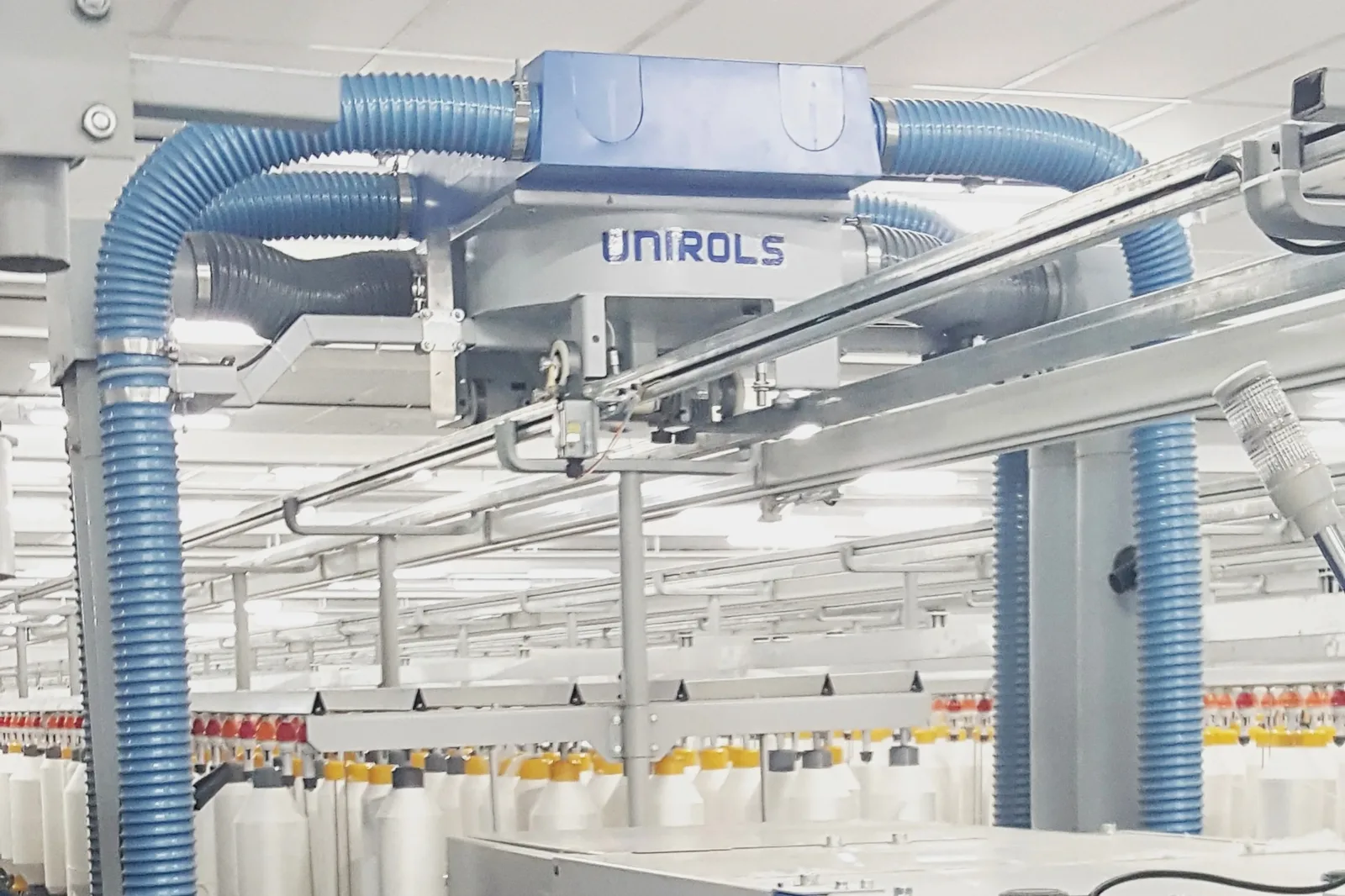 Overhead travelling cleaner installed above a ring spinning machine
